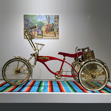 a lowrider tricycle bike created by the Olathe lowrider bike club on display at an exhibition