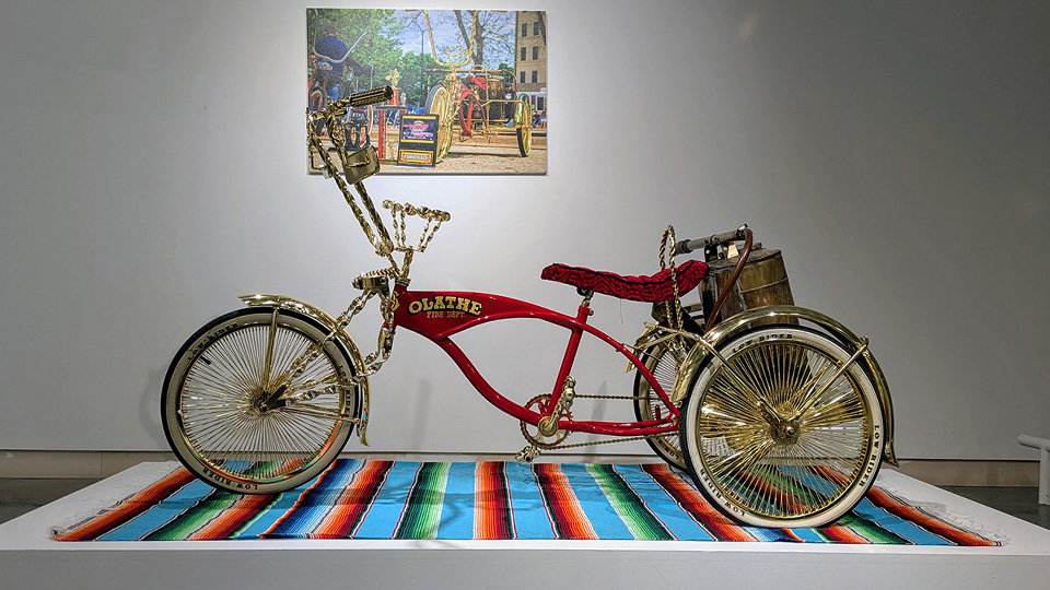 a lowrider tricycle bike created by the Olathe lowrider bike club on display at an exhibition