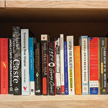 a row of books on a wooden shelf