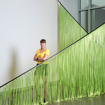 Cory Imig standing next to her artwork "Linear Spaces"