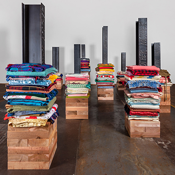 Sun drinks white art installation - folded blankets, steel beams and cedar boxes
