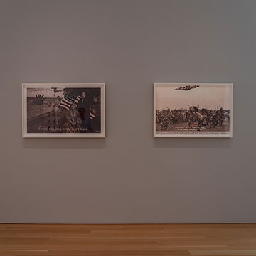 Two black and white photos of Native American groups depicted with a full colored American flag. The works are hanging on the wall in a Nerman gallery.