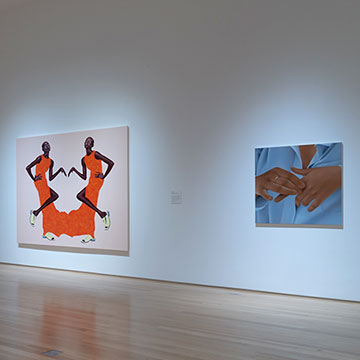 A view of the gallery installation of the New Chapter exhibition showing three distinct works: one a painting of a group of four people standing in patterned dresses; one a work of an abstracted figure wearing orange on a light background- the figure is mirrored right and left; the third work is a closeup of hands in front of a button down shirt.