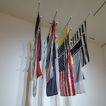 a group of flags hang from the gallery wall at the Nerman Museum