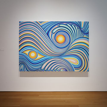 a painting of blue, pink and yellow swirls and circles on display at the Nerman Museum