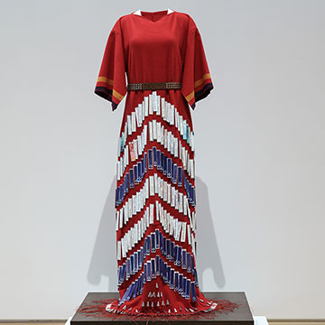 a floor-length dress of red fabric and blue and white embellishments
